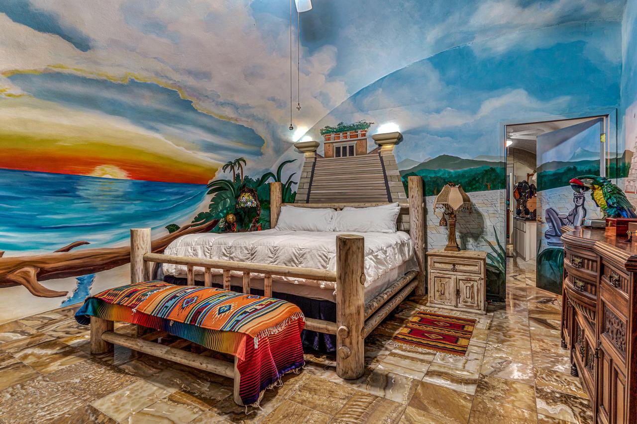 An intense sunset is painted on the dome wall of this bedroom.